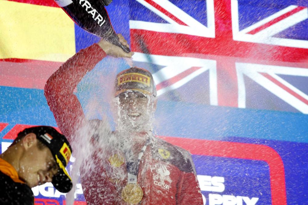 MARINA BAY STREET CIRCUIT, SINGAPORE - SEPTEMBER 17: Carlos Sainz, Scuderia Ferrari, 1st position, pours Champagne over himself in celebration on the podium during the Singapore GP at Marina Bay Street Circuit on Sunday September 17, 2023 in Singapore, Singapore. (Photo by Glenn Dunbar / LAT Images)