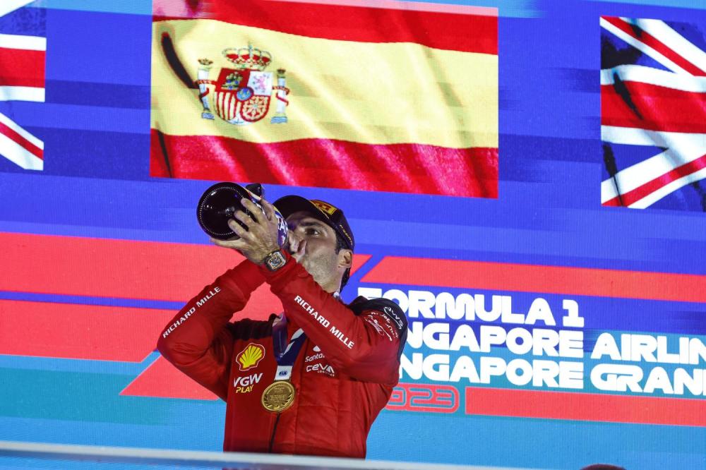 MARINA BAY STREET CIRCUIT, SINGAPORE - SEPTEMBER 17: Carlos Sainz, Scuderia Ferrari, 1st position, drinks the victory Champagne during the Singapore GP at Marina Bay Street Circuit on Sunday September 17, 2023 in Singapore, Singapore. (Photo by Steven Tee / LAT Images)