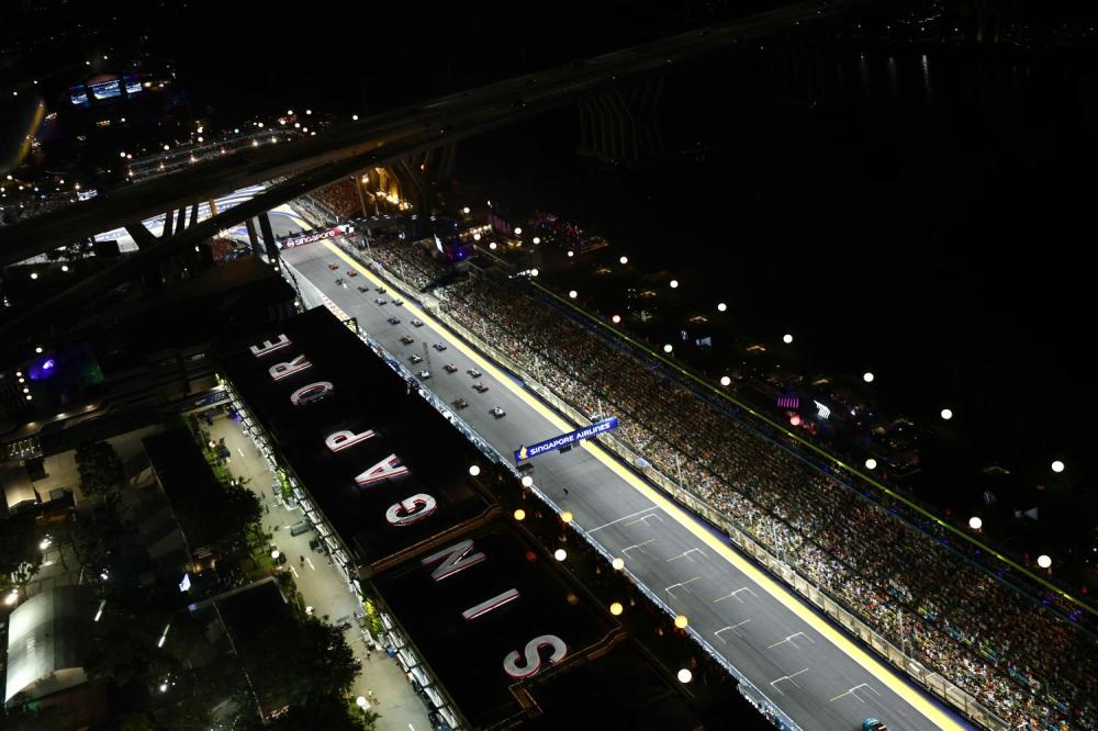 MARINA BAY STREET CIRCUIT, SINGAPORE - SEPTEMBER 17: Carlos Sainz, Ferrari SF-23, leads Charles Leclerc, Ferrari SF-23, George Russell, Mercedes F1 W14, Lando Norris, McLaren MCL60, Sir Lewis Hamilton, Mercedes F1 W14, and the rest of the field at the start during the Singapore GP at Marina Bay Street Circuit on Sunday September 17, 2023 in Singapore, Singapore. (Photo by Zak Mauger)