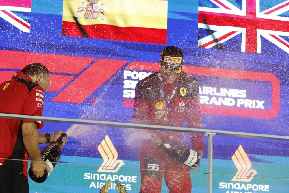 MARINA BAY STREET CIRCUIT, SINGAPORE - SEPTEMBER 17: Carlos Sainz, Scuderia Ferrari, 1st position, and Frederic Vasseur, Team Principal and General Manager, Scuderia Ferrari, spray the victory Champagne during the Singapore GP at Marina Bay Street Circuit on Sunday September 17, 2023 in Singapore, Singapore. (Photo by Steven Tee / LAT Images)